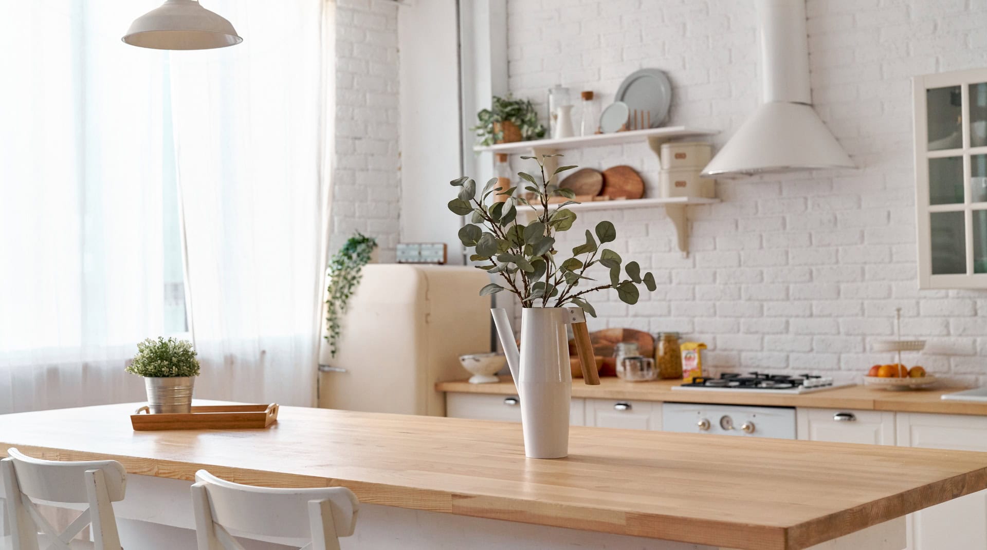 Bright minimalist zero waste kitchen with natural wood countertops, indoor plants, and reusable decor — an example of zero waste kitchen essentials.